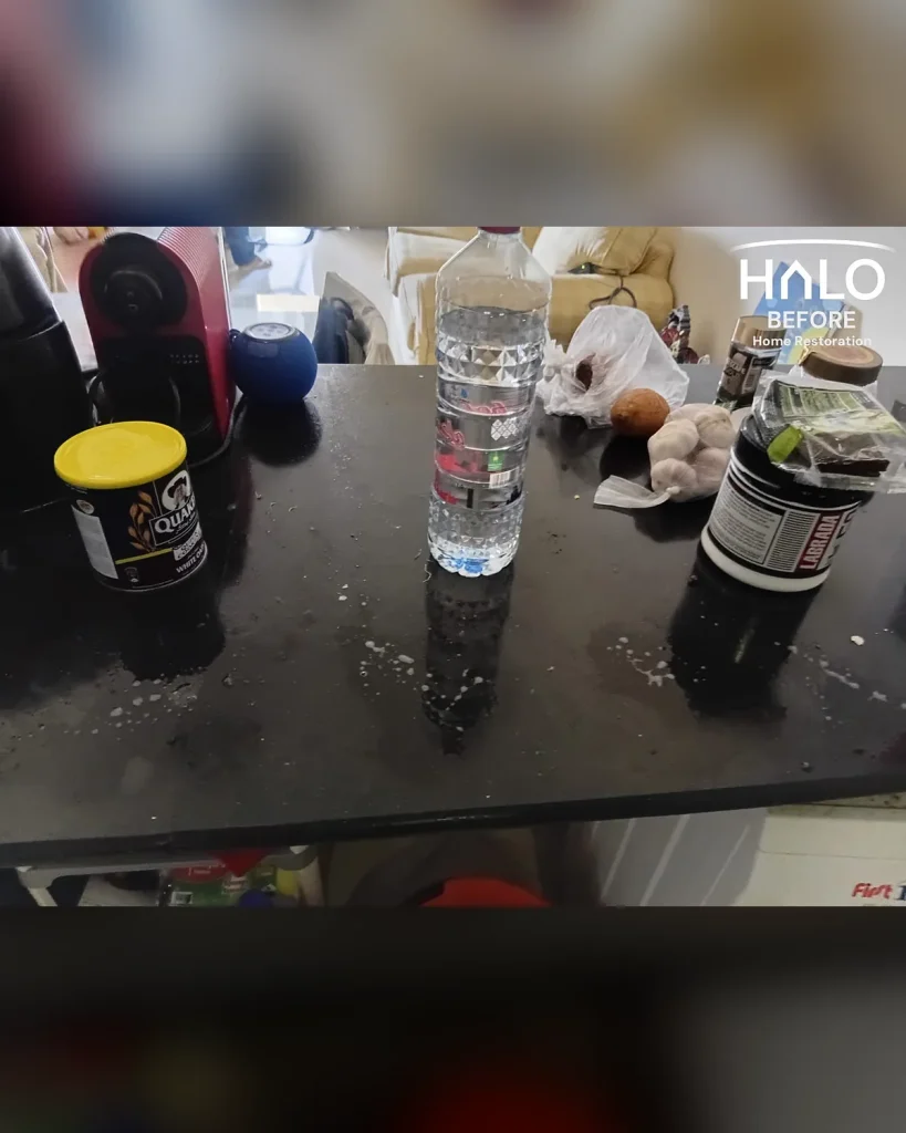 Before a kitchen deep clean in Ras Al Khaimah - worktop littered with crumbs, food packaging and dried spills